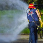 Safety Tips - A firefighter spraying water on a road