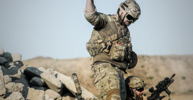 Missions - 2 Soldier With Guns on Grey Pile of Rocks Holding Smoke Stick during Daytime