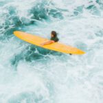 Ocean Currents - Man with a Yellow Surfboard in Rough Turquoise Water