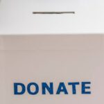 Benefits - Crop anonymous person showing donation box